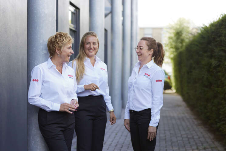 Smiling Securitas security officer, Three Securitas security officers smiling at each other in a team setting